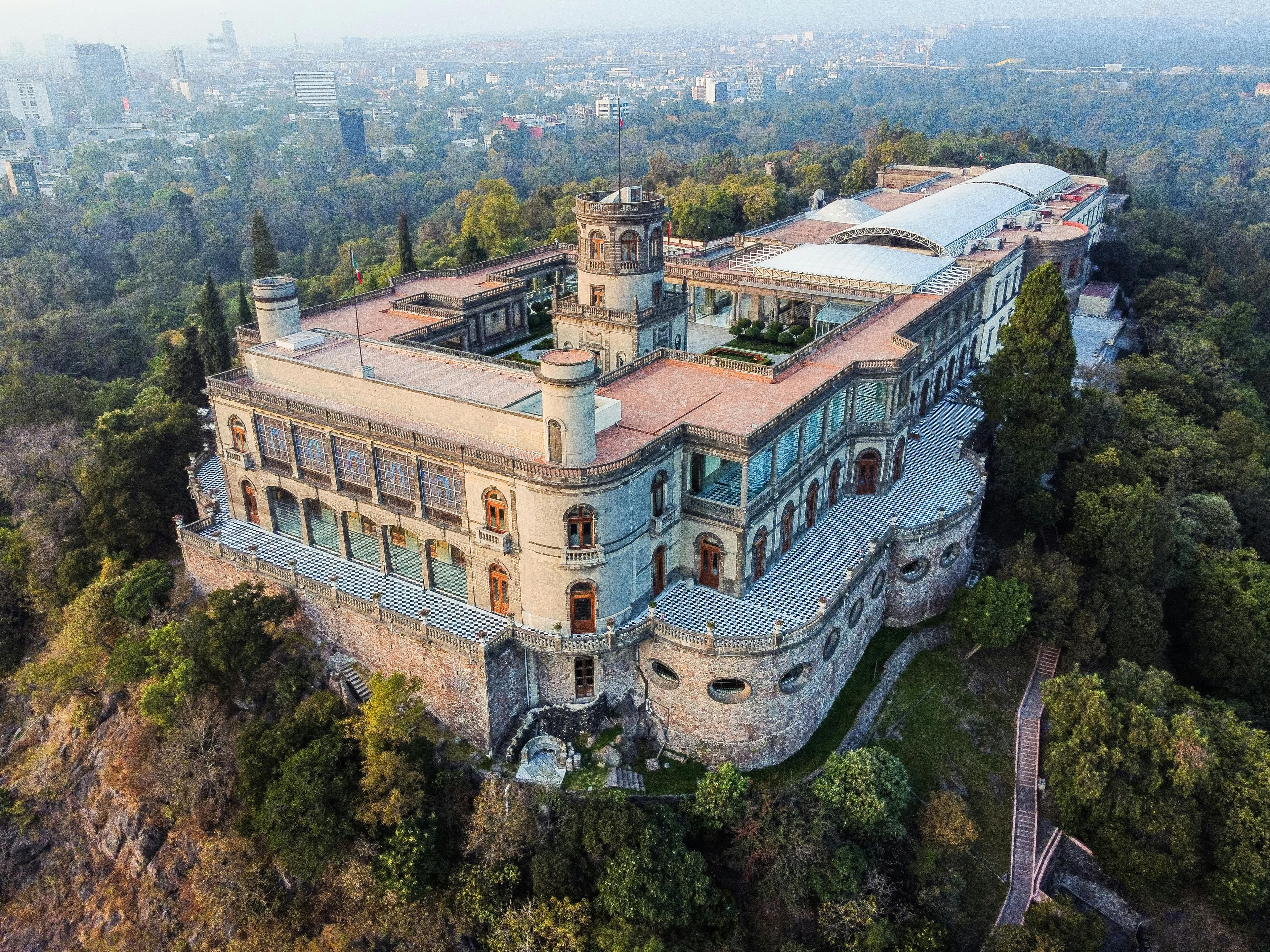 Chapultepec Castle sits atop a lush hill overlooking the sprawling urban landscape of Mexico City.